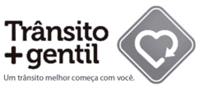 Peça de campanha educativa contendo texto e imagem. À esquerda, lê-se em destaque 'Trânsito + gentil'. Abaixo, em fonte menor, o slogan 'Um trânsito melhor começa com você'. À direita, há uma moldura em formato de losango, semelhante a uma placa de trânsito de advertência. Dentro do losango, há o desenho de um coração formado por uma linha contínua que termina em uma seta, lembrando um símbolo de renovação ou ciclo.